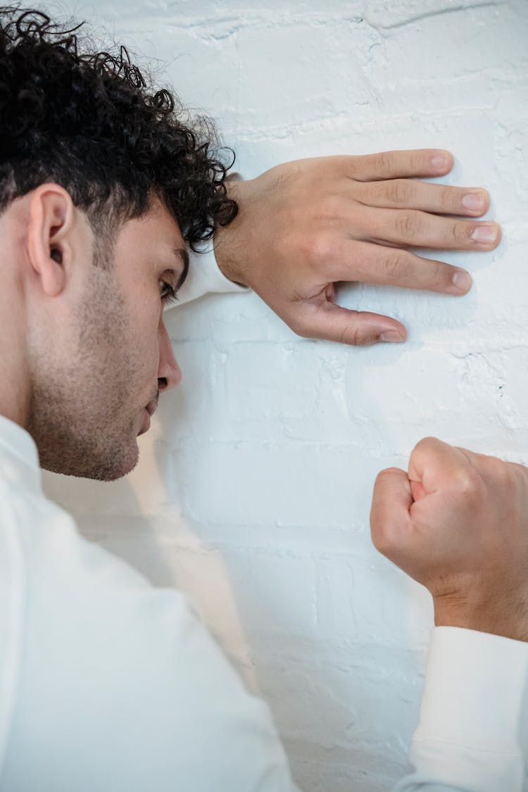 A Man Punching The White Wall