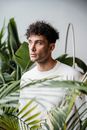 A Sad Man in White Long Sleeves Shirt Standing Near Green Plants while Looking Afar