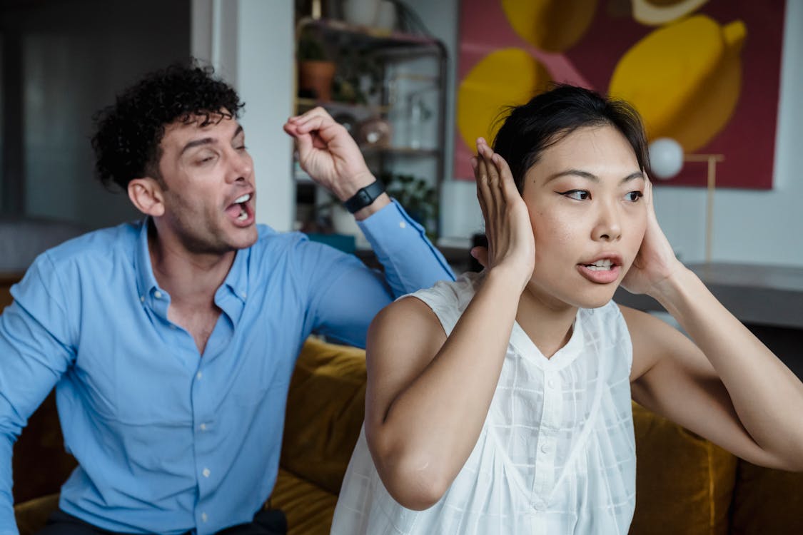 Free A Man and a Woman Sitting on a Couch while Having an Argument Stock Photo