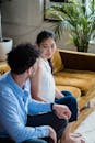 A Couple Holding Each Others Hand while Sitting on a Couch