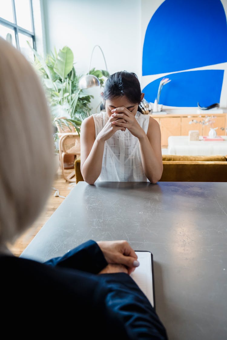 A Sad Woman Sitting At The Table 