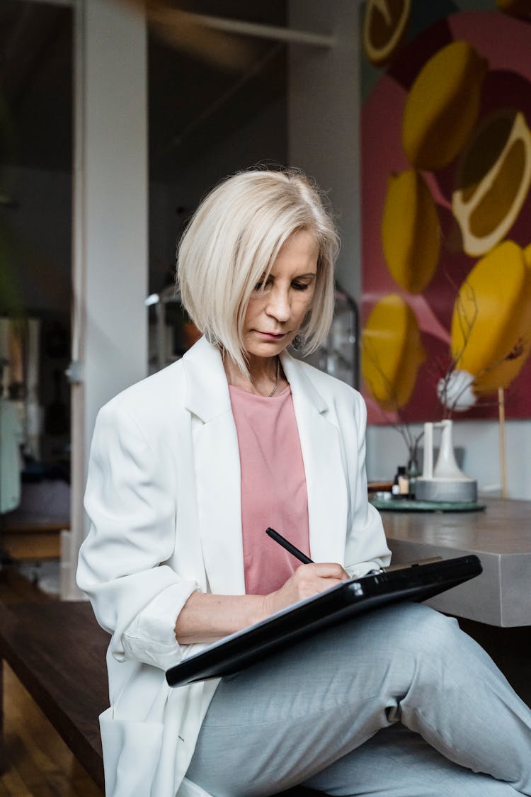 A Woman Writing On The Clipboard