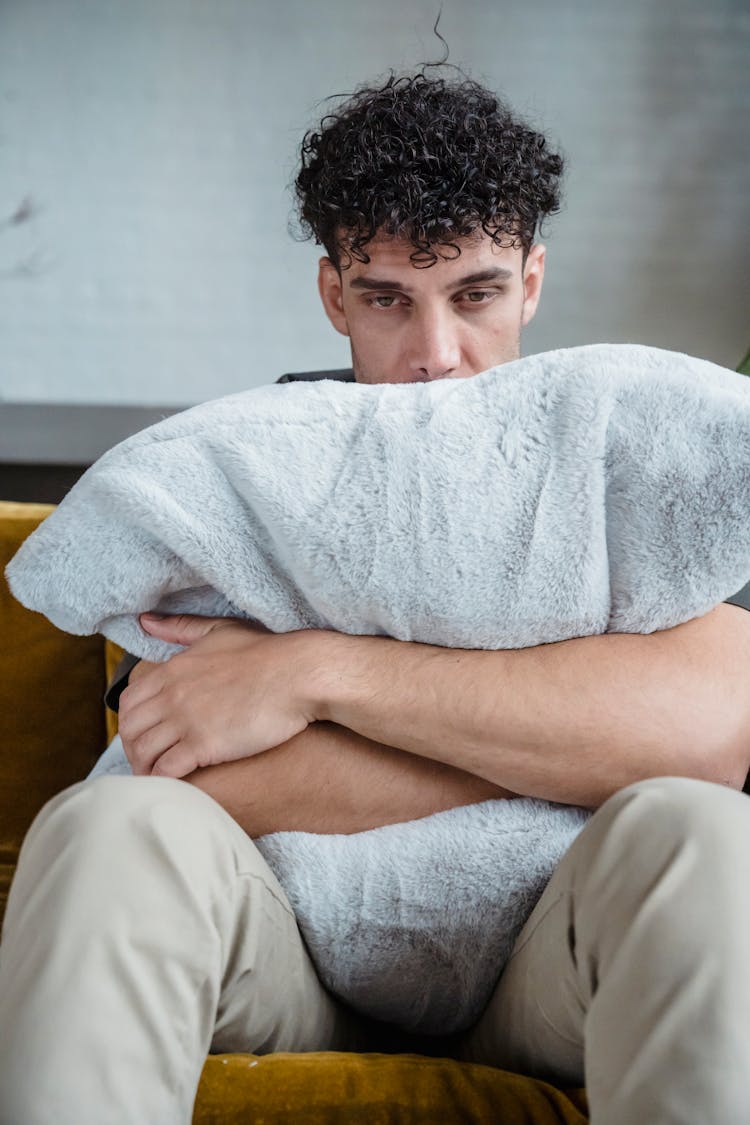 Emotional Man Hugging A Pillow