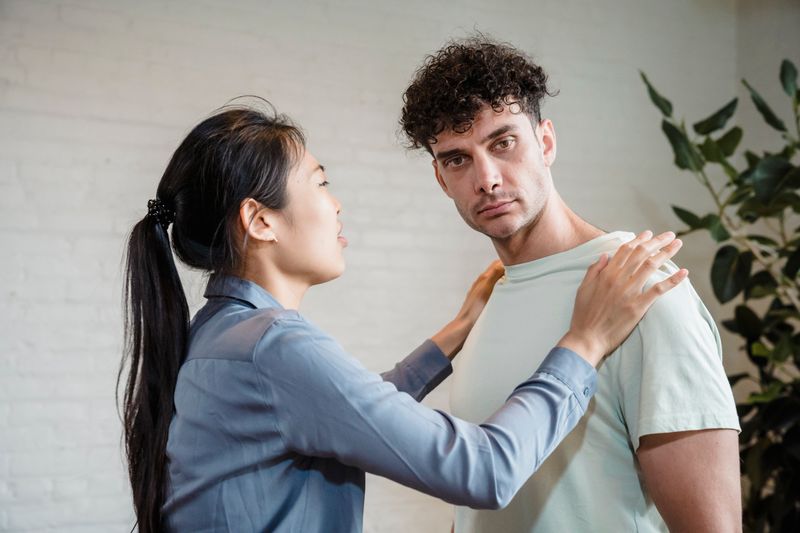 Man and woman engaging in a serious discussion indoors, expressing emotions.
