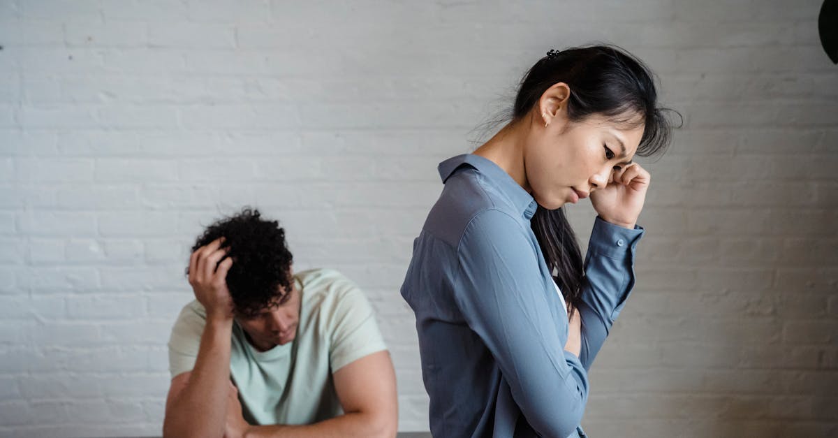 An Asian woman and man feeling misunderstood and frustrated in a relationship indoors.