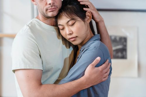 Free A tender moment between an interracial couple sharing a comforting embrace indoors. Stock Photo