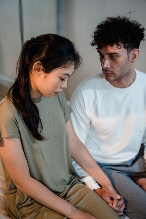 Free An intimate moment between a young couple holding hands inside a room. Stock Photo