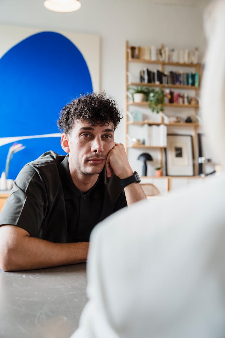 Sleepy Man Sitting With Hand On Cheek 