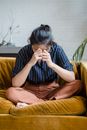 Person Crying While Sitting on a Yellow Couch