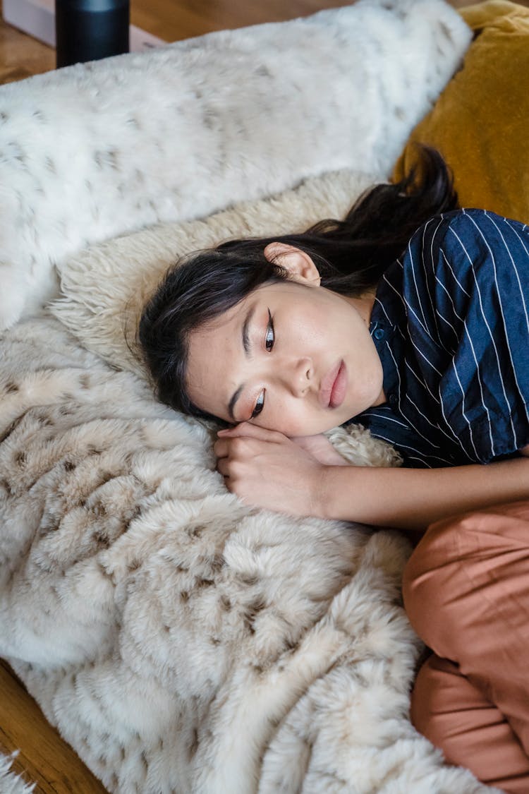 Sad Woman Lying On A Faux Fur Blanket 