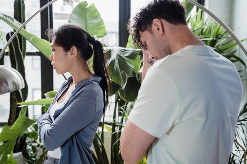 Free A couple argues in a lush indoor garden, creating a tense atmosphere. Stock Photo