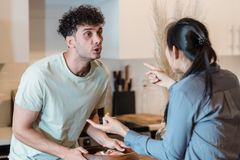 A couple engages in a heated discussion in a contemporary kitchen, highlighting relationship dynamics.
