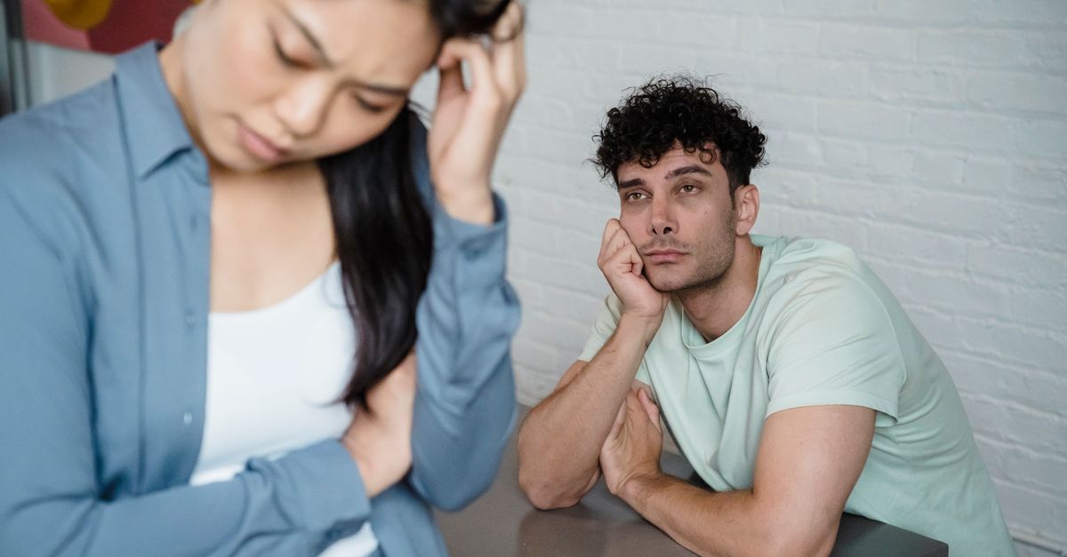 A man and woman deep in thought facing relationship tension, visible emotions in an indoor setting.