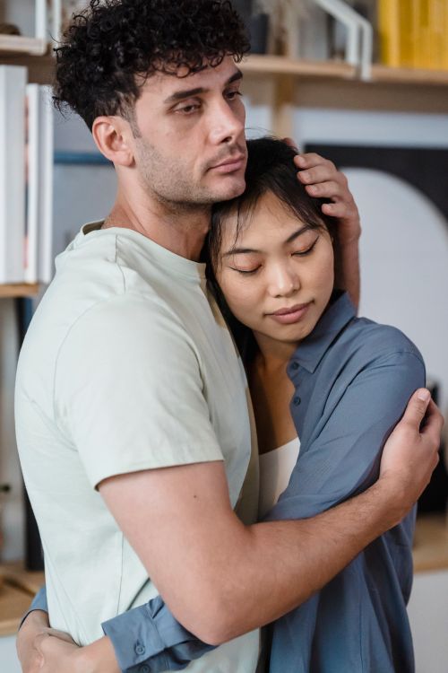 Free A couple shares a tender embrace indoors, showcasing affection and intimacy. Stock Photo