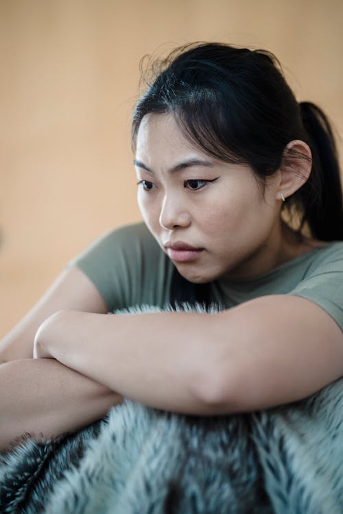 Young Upset Woman Sitting Under a Blanket 