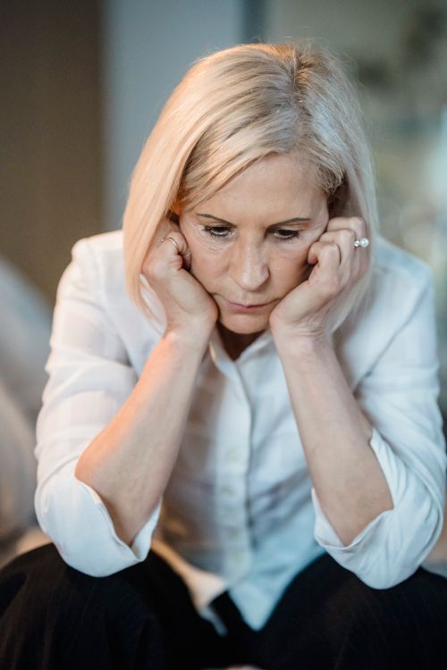 Free Thoughtful senior woman resting head on hands, indoors. Reflecting on life's challenges. Stock Photo