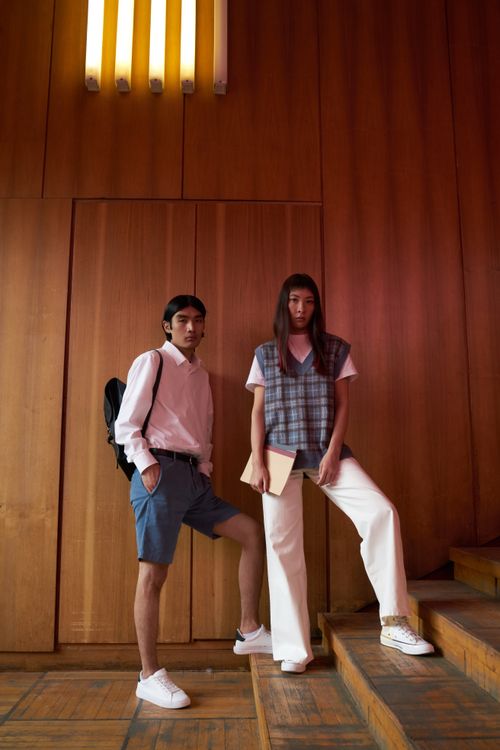 Free Fashionable man and woman posing confidently on stairs in modern apparel. Stock Photo