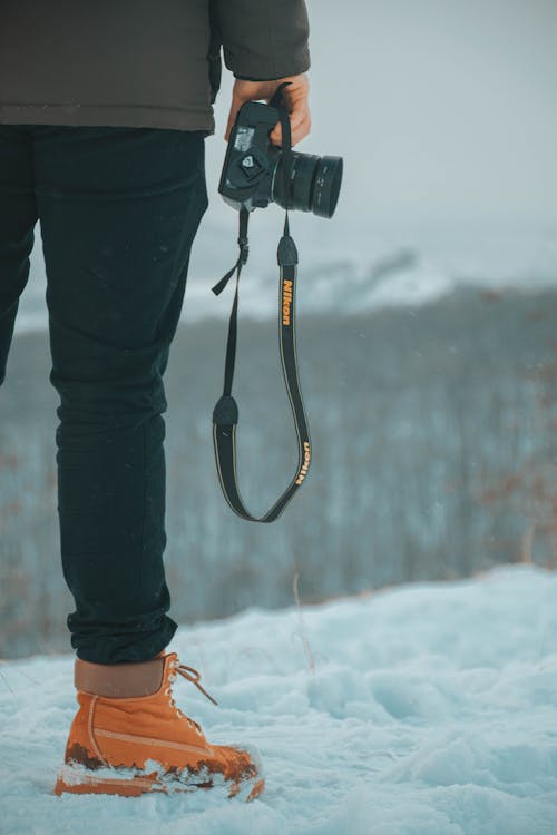 Close up of Man Standing with Camera in Snow