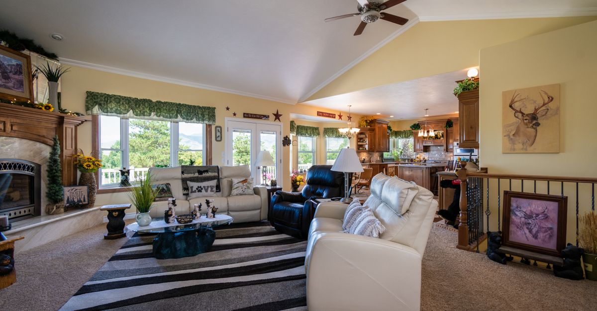 Spacious living room featuring a fireplace, modern decor, and comfortable furniture, with a view to the outdoors.