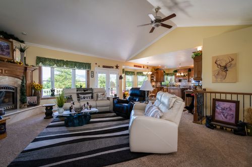 Free Spacious living room featuring a fireplace, modern decor, and comfortable furniture, with a view to the outdoors. Stock Photo