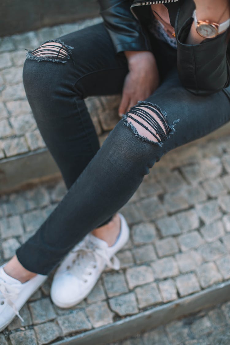 Unrecognizable Woman In Jeans Sitting On Stairs