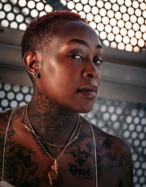Free Portrait of a woman with tattoos and nose piercing, showcasing her unique style and confidence. Stock Photo