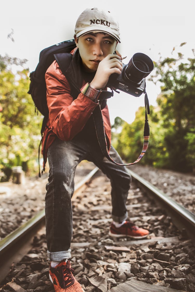 Young Man In Red Jacket Holding Camera