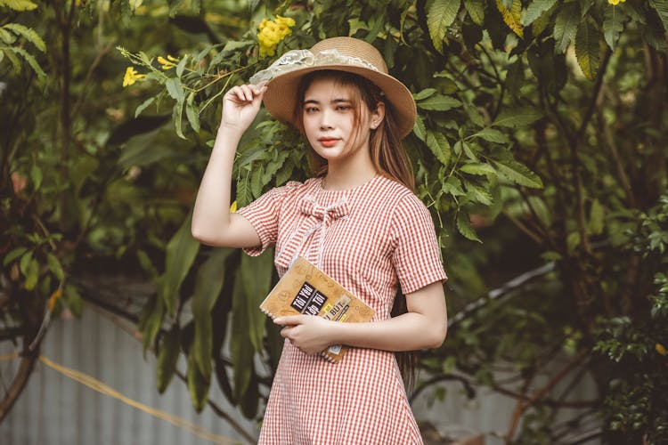 Girl In Red And White Plaid Dress Holding Brown Notebook