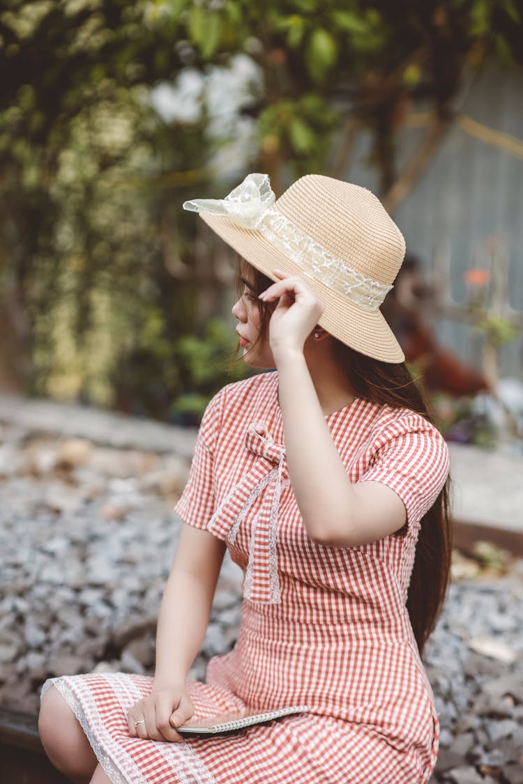 Woman In Red And White Plaid Dress Holding Brown Straw Hat