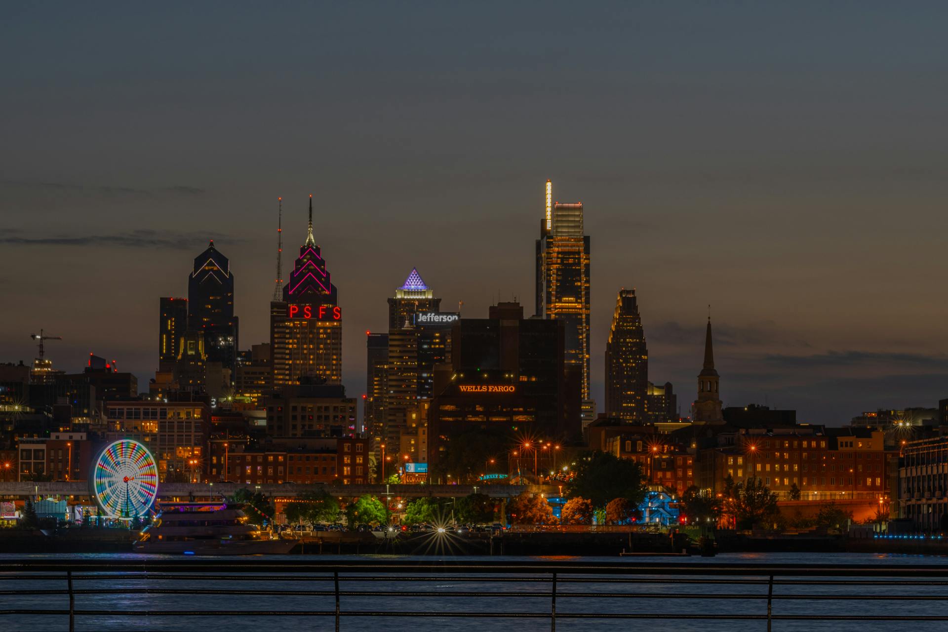 Stunning view of Philadelphia skyline illuminated at night with a Ferris wheel.