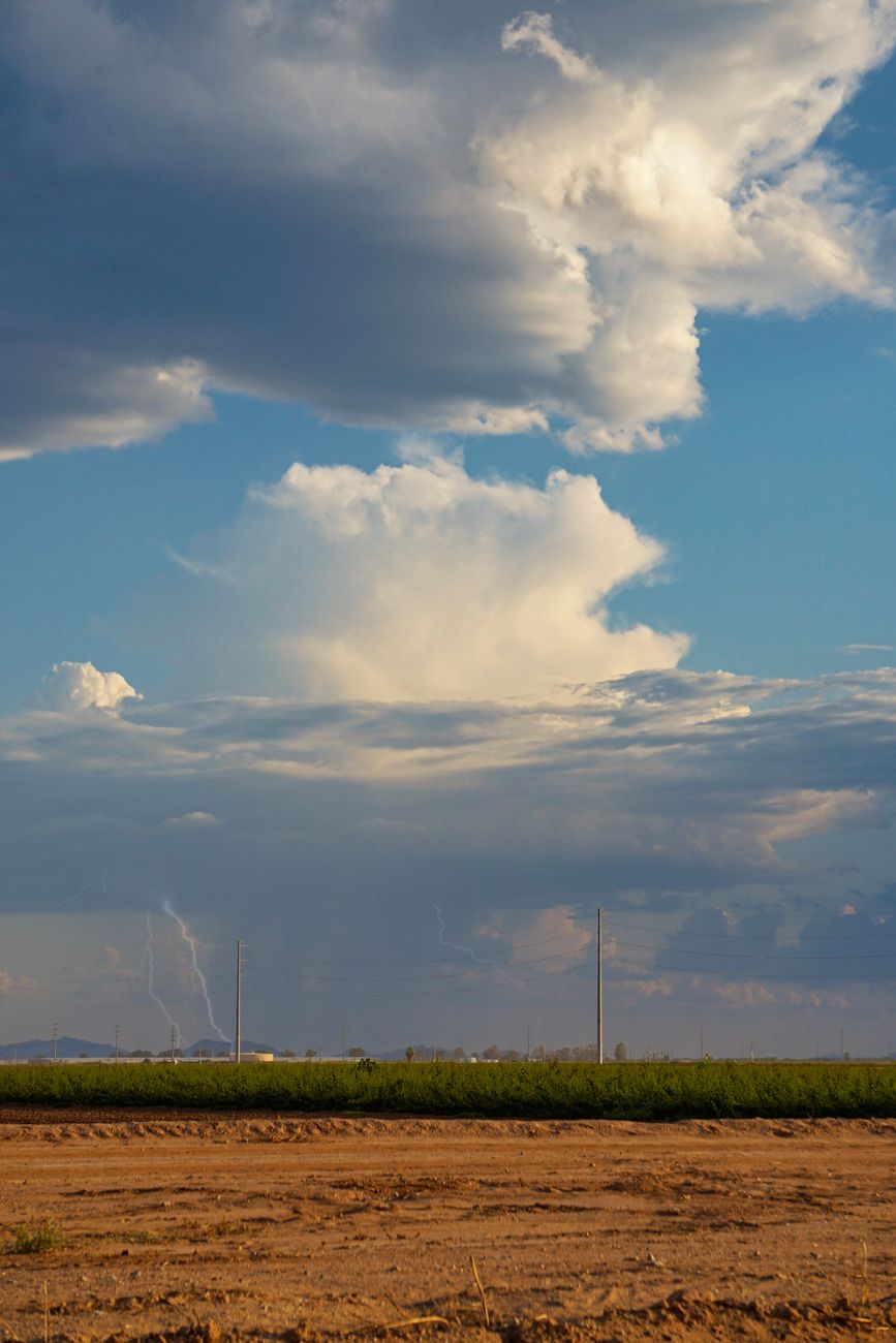 dramatic storm clouds and lightning bolt over an Arizona landscape during monsoon season