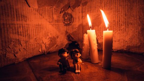A warm candlelit setting featuring small figurines in a cozy still life arrangement.