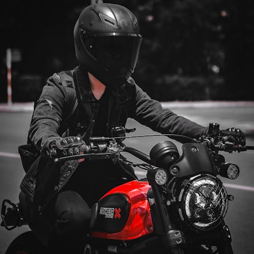 Person Riding a Black and Red Motorcycle