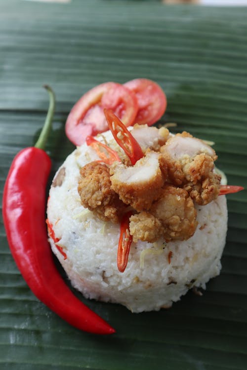 Free Rice with Pork Topping Beside a Red Pepper Stock Photo