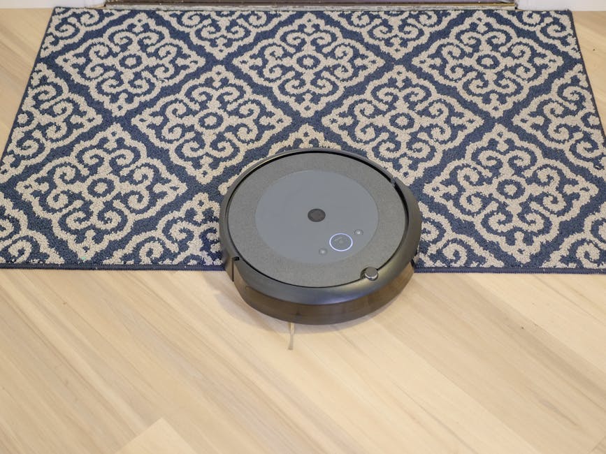 Carpet Cleaning Services Montreal 3 CARPET CLEANING SERVICES MONTREAL - A MODERN ROBOTIC VACUUM CLEANING A STYLISH PATTERNED CARPET ON A WOODEN FLOOR.