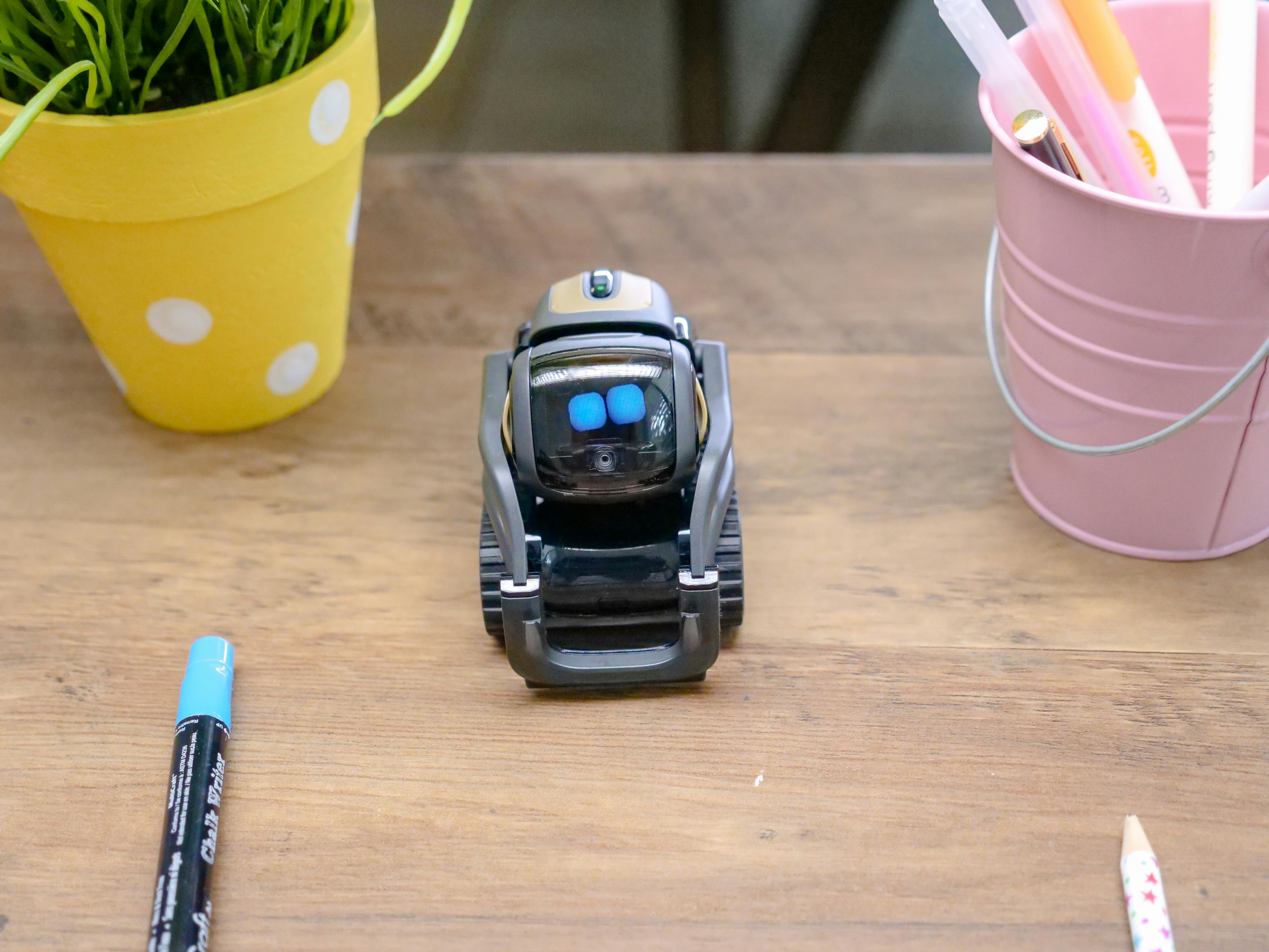 black miniature robot toy on wooden surface