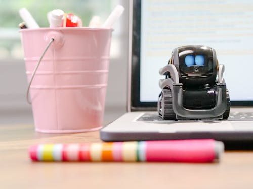 Free MIniature Toy Robot on Top of Laptop's Keyboard Stock Photo