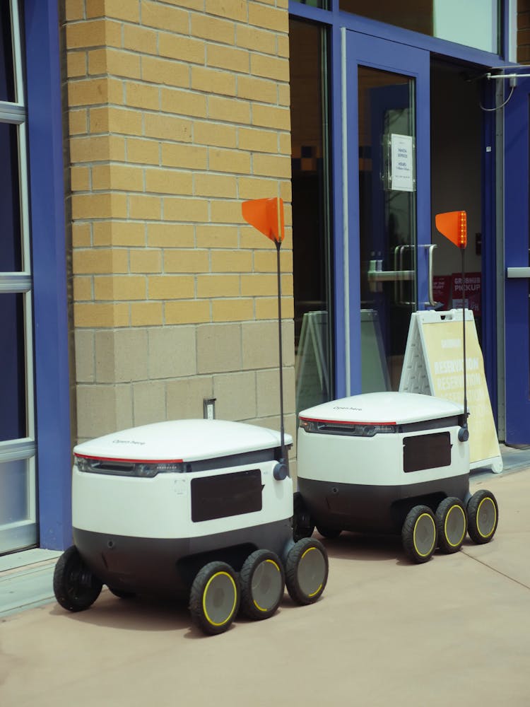 Automated Delivery Robots Beside A Brick Wall 