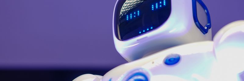 A modern humanoid robot with digital face and luminescent screen, symbolizing innovation in technology.