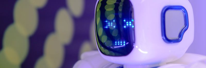 Close-up of a futuristic humanoid robot with a luminescent display in a modern setting.