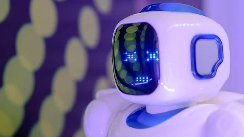 Close-up of a futuristic humanoid robot with a luminescent display in a modern setting.