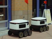 Delivery Robots Parked Beside Building