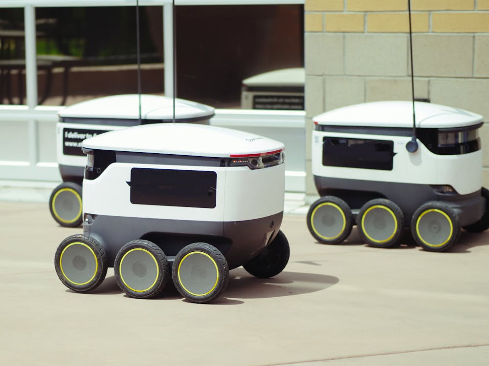 Free Advanced autonomous delivery robots in an outdoor urban setting, showcasing modern technology. Stock Photo