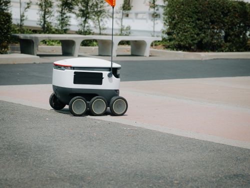 Free A modern autonomous delivery robot navigating an urban environment. Innovative technology for food delivery. Stock Photo