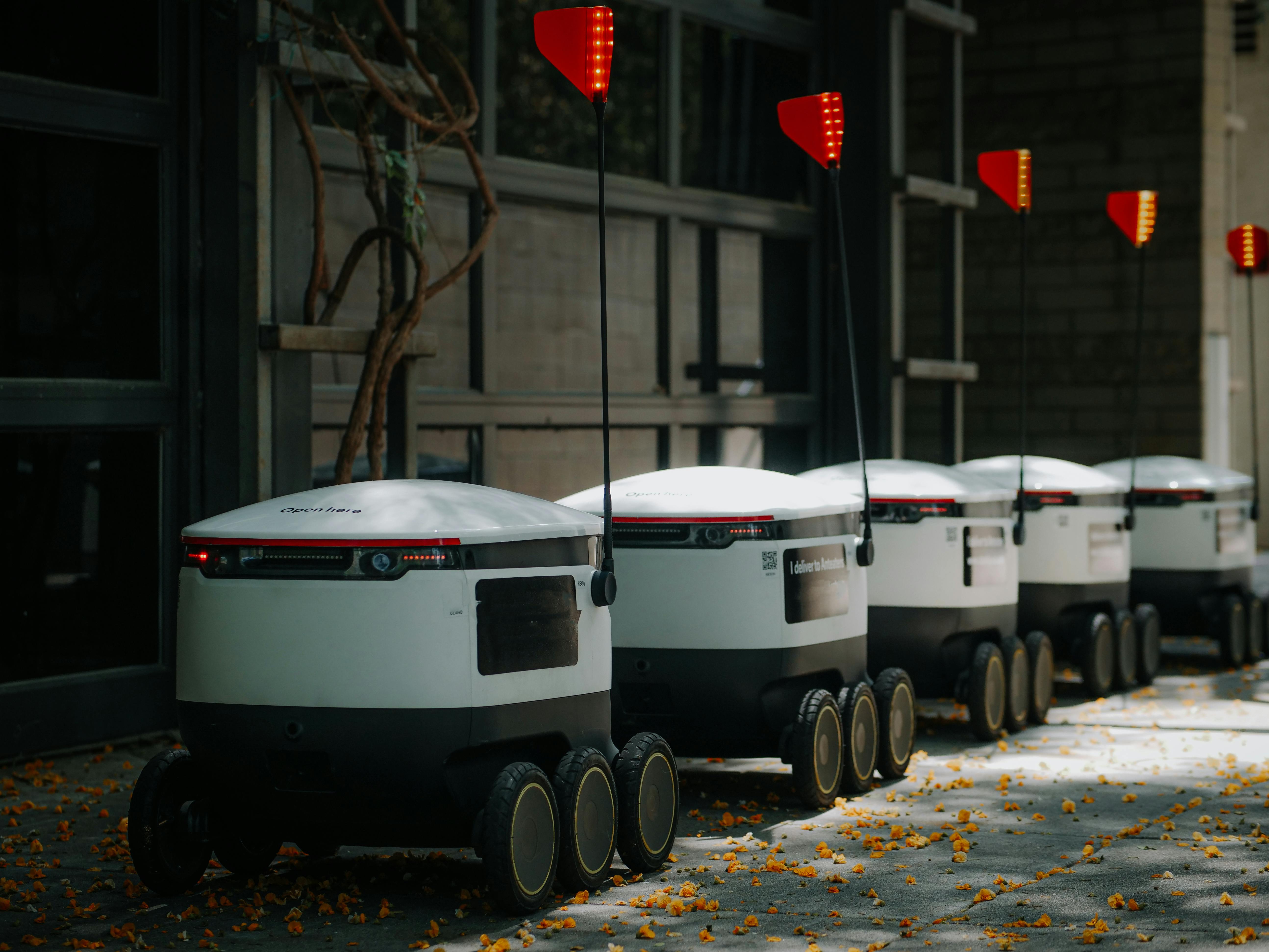 delivery robots parked beside glass wall