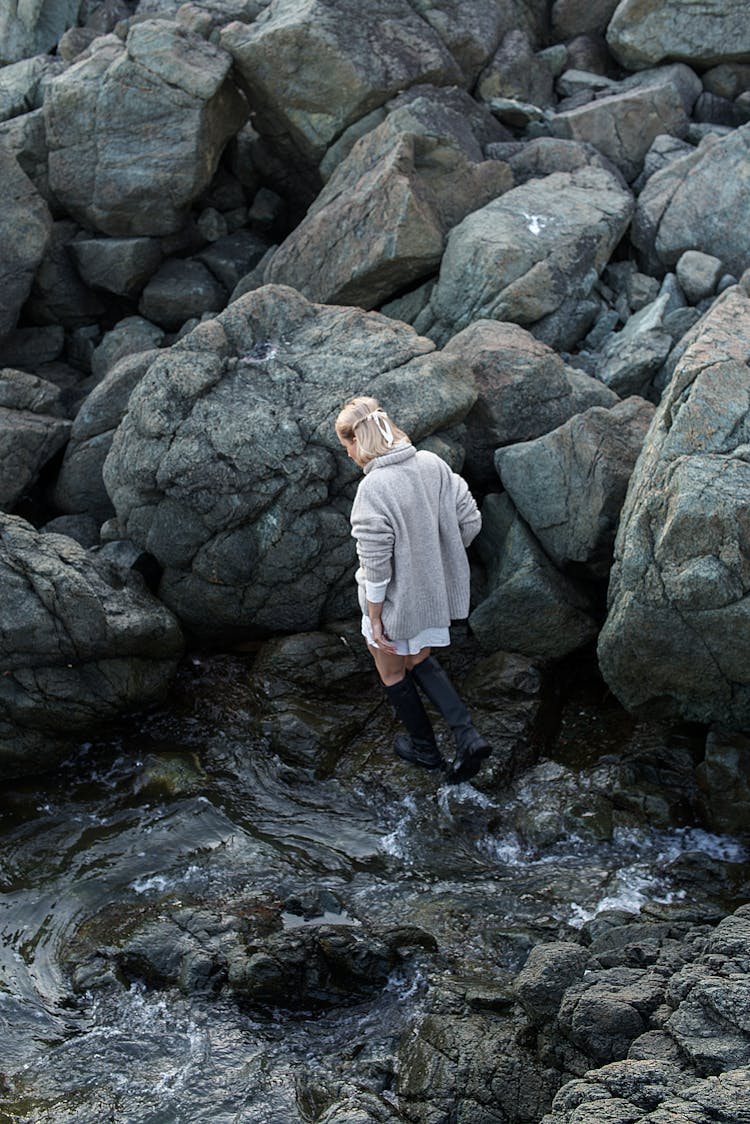 Woman On The Background Of Large Rocks On The Shore 