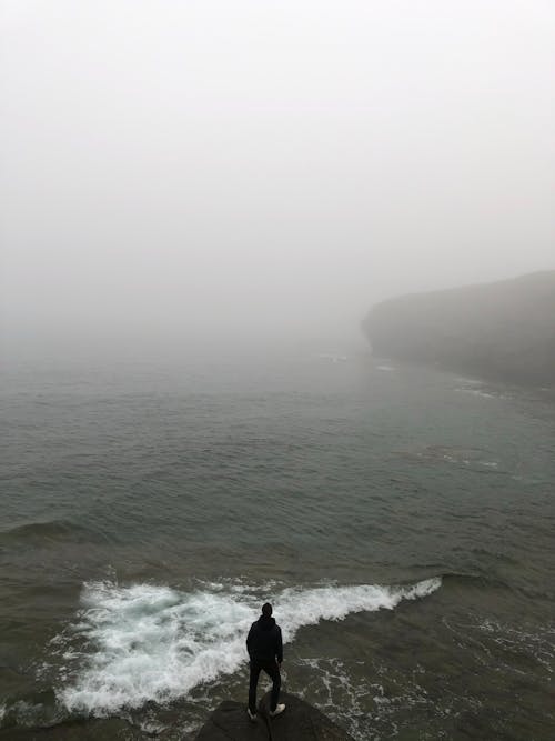 Person Standing at the Edge of a Cliff