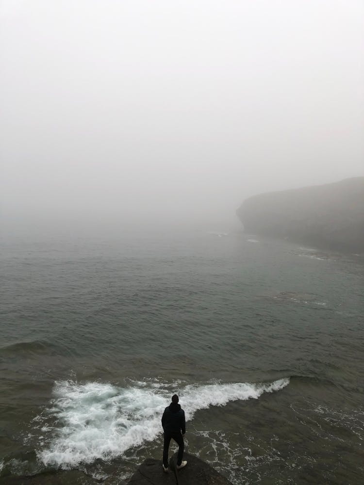 Person Standing At The Edge Of A Cliff