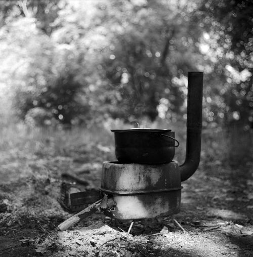 Free A rustic black and white scene with an iron cauldron cooking in a forest setting. Stock Photo