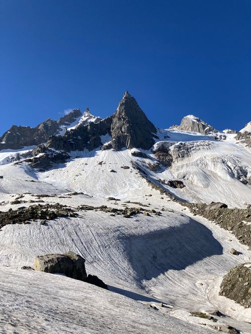 Free A stunning view of a snow-capped rocky mountain peak against a clear blue sky, capturing pure natural beauty. Stock Photo